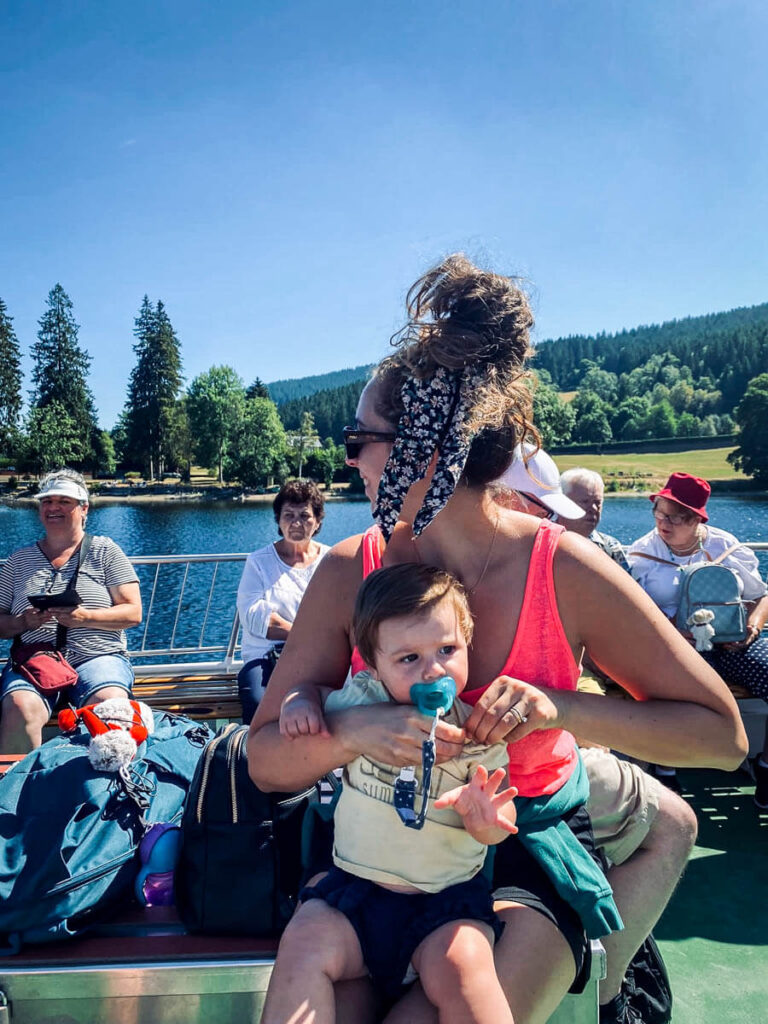 Mother holding her daughter on a Lake Titisee ferry boat ride on their European road trip with a baby.