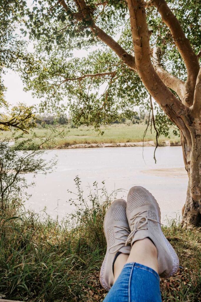 woman sitting at rest camp in front of water at Kruger National Park