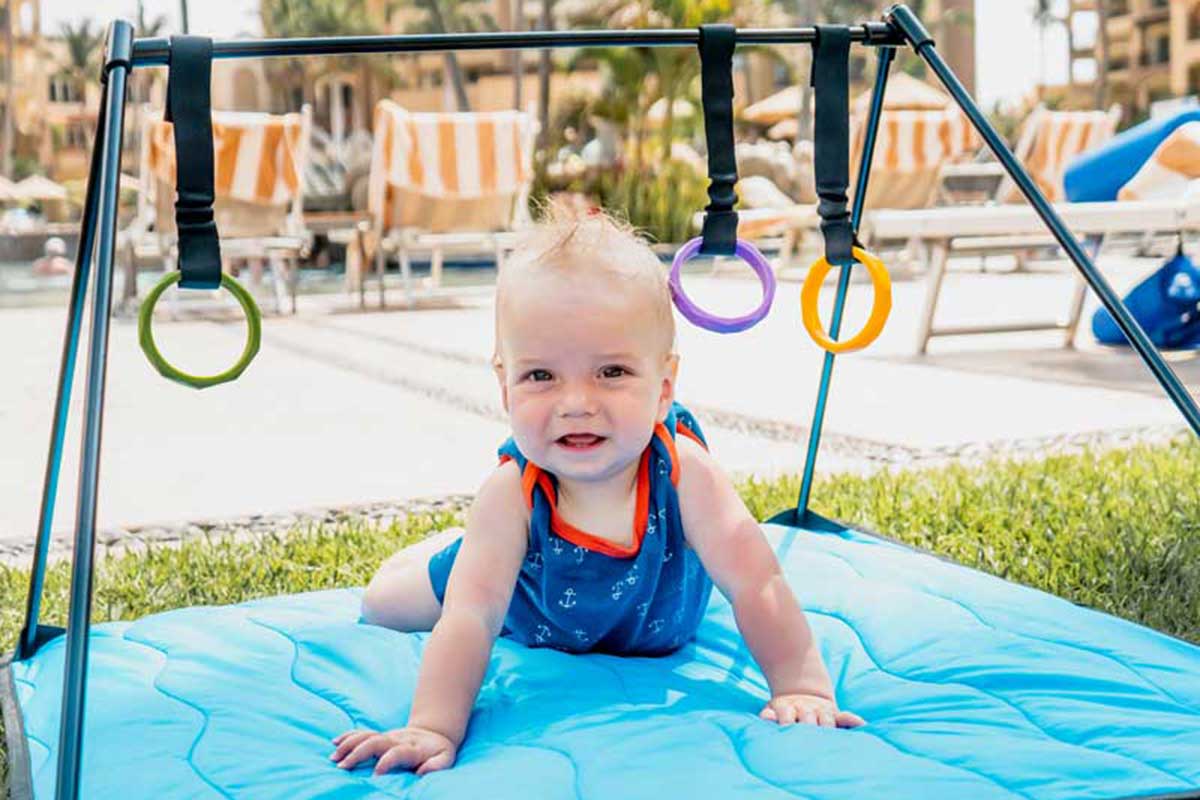 Baby playing on play mat on grass