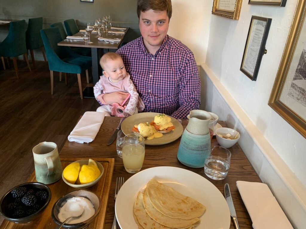 Man holding baby eating at Bowleys Restaurant Kent UK