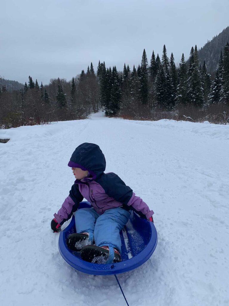 toddler sledding in Jacque Cartier National Park Quebec in Winter