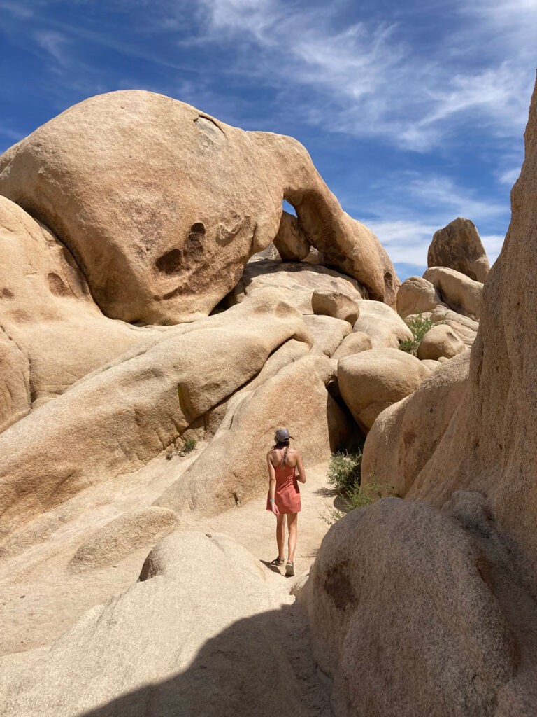 woman walking near rock formations - Best Things to do in Joshua Tree National Park