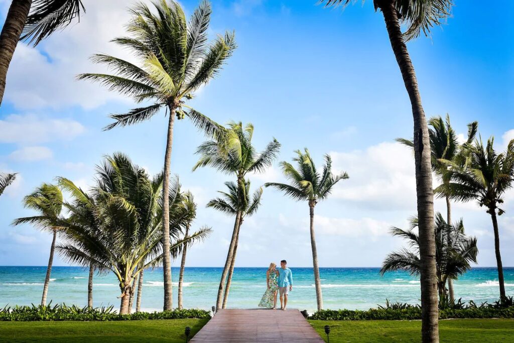 A couple enjoys a happy moment by the Caribbean Sea at the Grand Velas Riviera Maya all-inclusive resort.