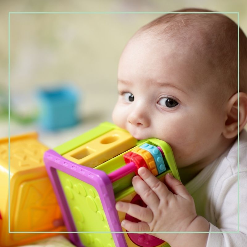 baby chewing on baby travel toy