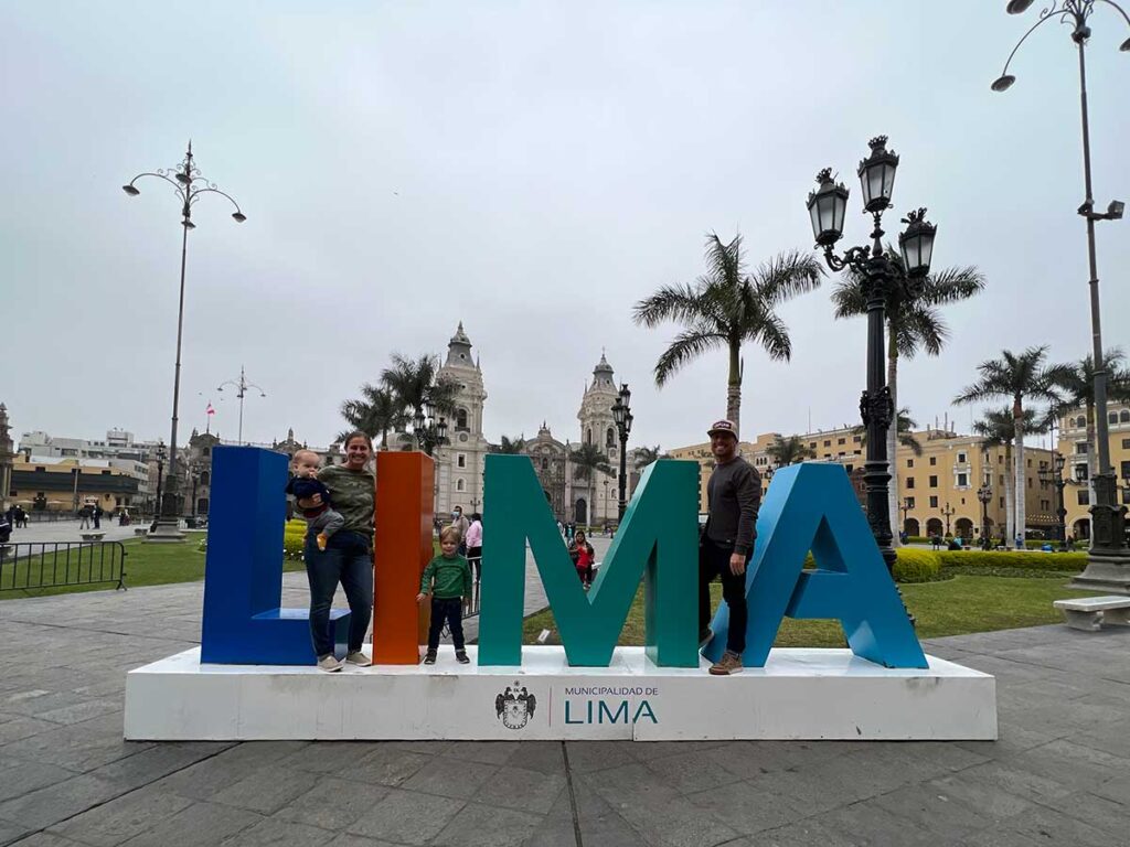 family posing on Lima sign at El centro historicon in Lima Peru with toddlers