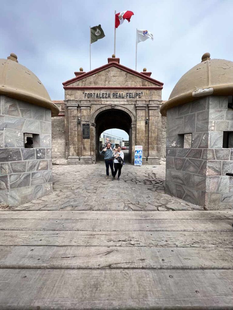 family at entrance of Fortaleza del Real Filipe in Lima with toddlers