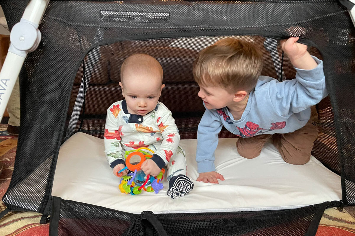 baby and toddler playing in Guava lotus travel crib for babies and toddlers