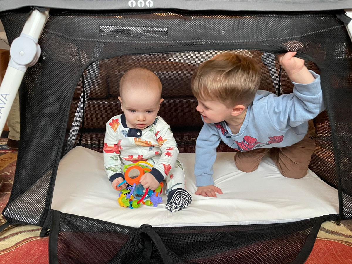 baby and toddler playing in Guava lotus travel crib for babies and toddlers