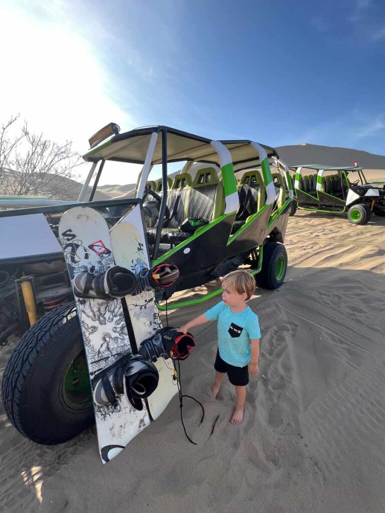 toddler standing near sand boards at Huacachina - Peru with a toddler