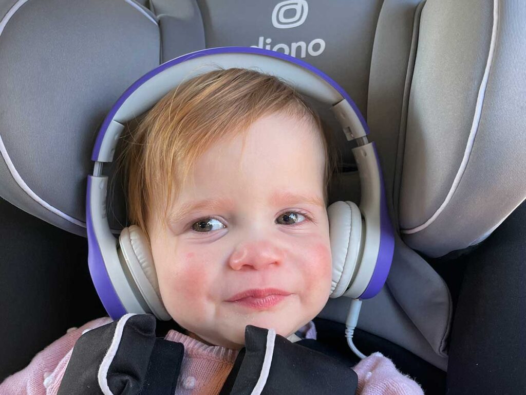 a child listens to LilGadgets Connect+ Toddler Headphones on a plane.