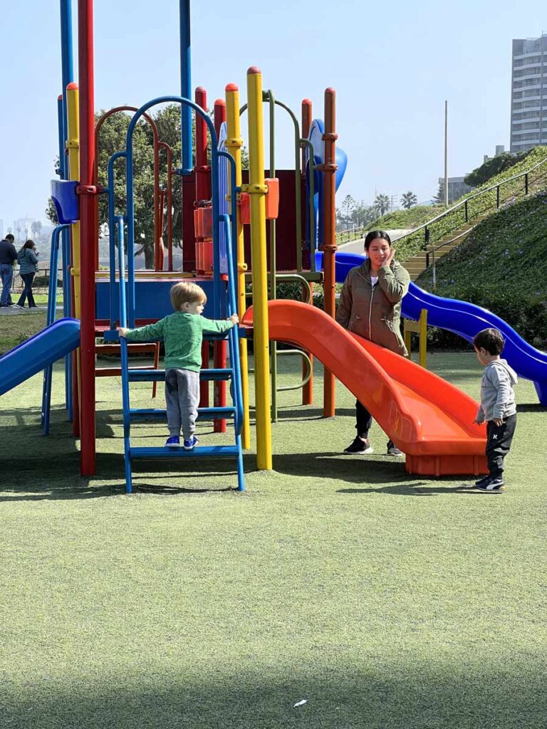 toddler climbing on Malecon Playground