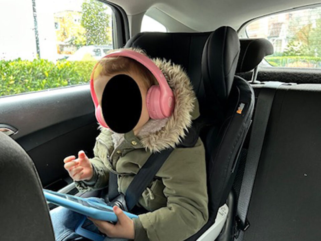 a toddler watches a show on a tablet using Mokata Headphones for Toddlers for road trips.