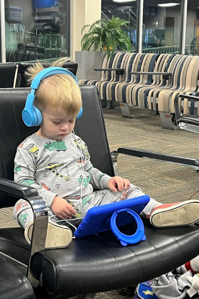 a toddler uses Snug Play+ Kids Toddler headphones for planes at the airport.