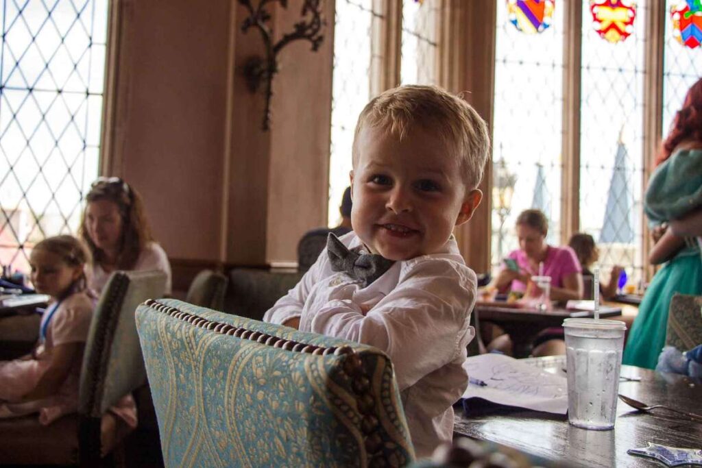 a handsome toddler is all dressed up to meet the Disney Princesses on a family vacation to Orlando, Florida