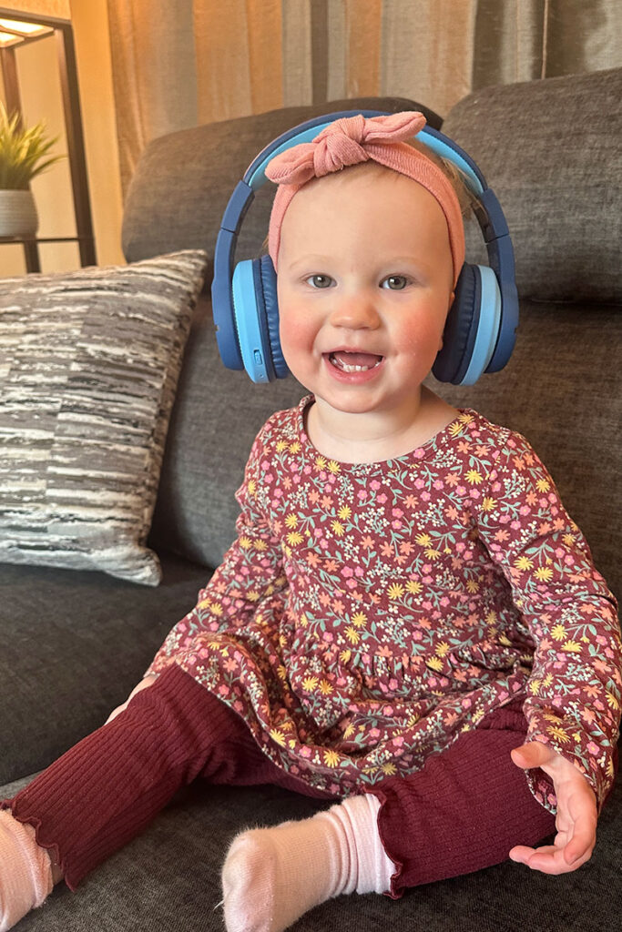 a happy child listens to music on iClever BTH12 Bluetooth headphones for 2 year old.