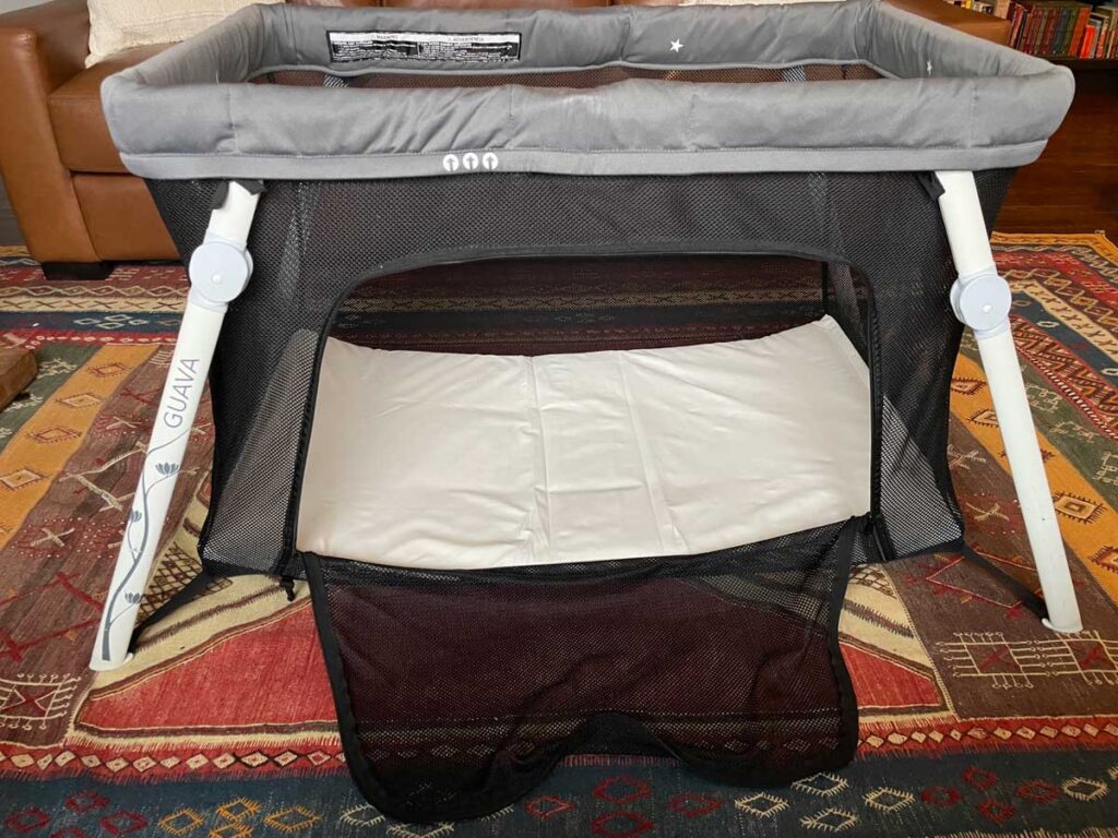 the lotus portable crib with the side door zipper open