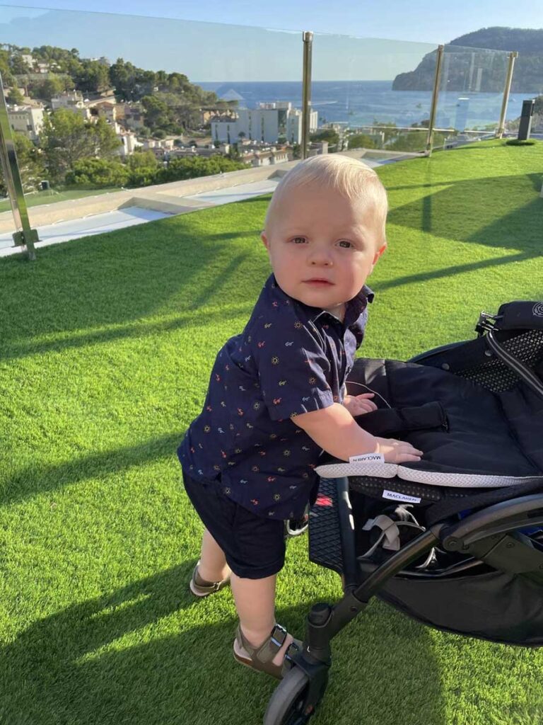 toddler standing near stroller - struggle with nap time while traveling.