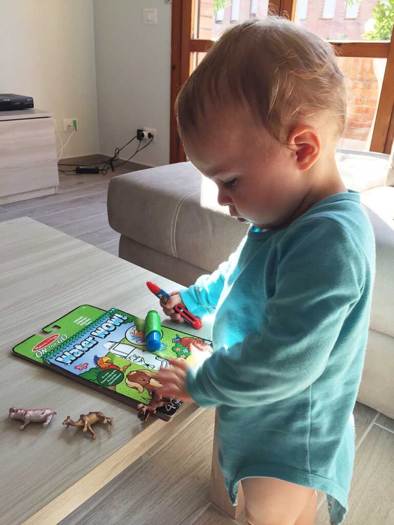 A toddler from BabyCanTravel.com colors a on Melissa & Doug Water Wow activity book while on a family vacation.