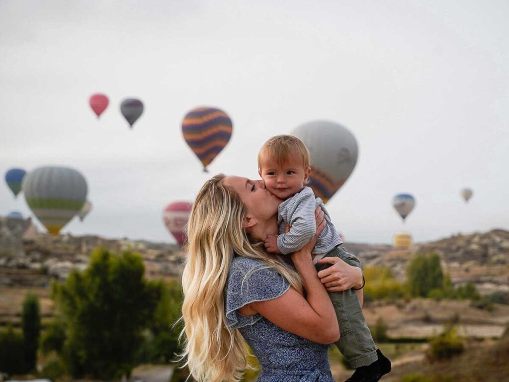 Mother holding baby near Cappadocia Hot Air Balloons