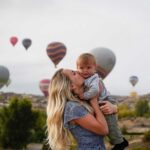 Mother holding baby near Cappadocia Hot Air Balloons