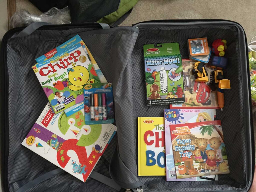 a real life example of the screen free travel toys for toddlers Celine Brewer (of BabyCanTravel.com) packed in a suitcase for a family vacation.