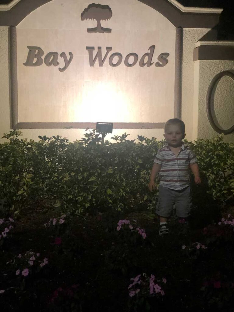 Toddler in front of Bay Woods sign