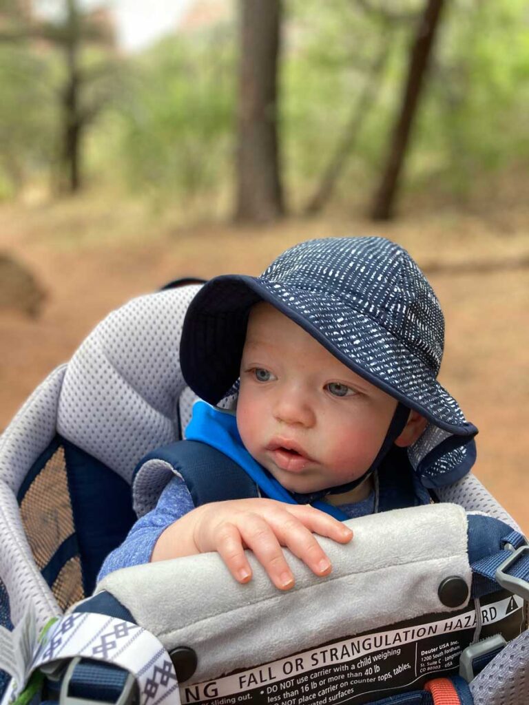 Toddler in sun hat in Deuter Kid Comfort Active Hiking Carrier.