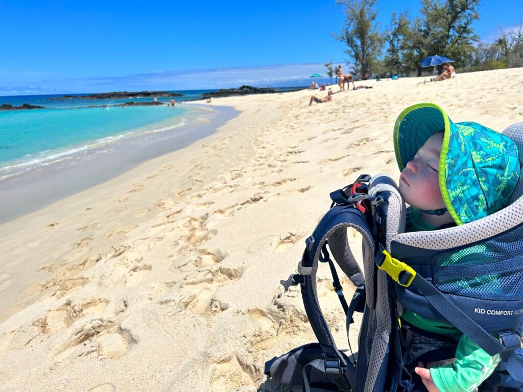 baby asleep on beach in Deuter Kid Comfort Active Carrier.