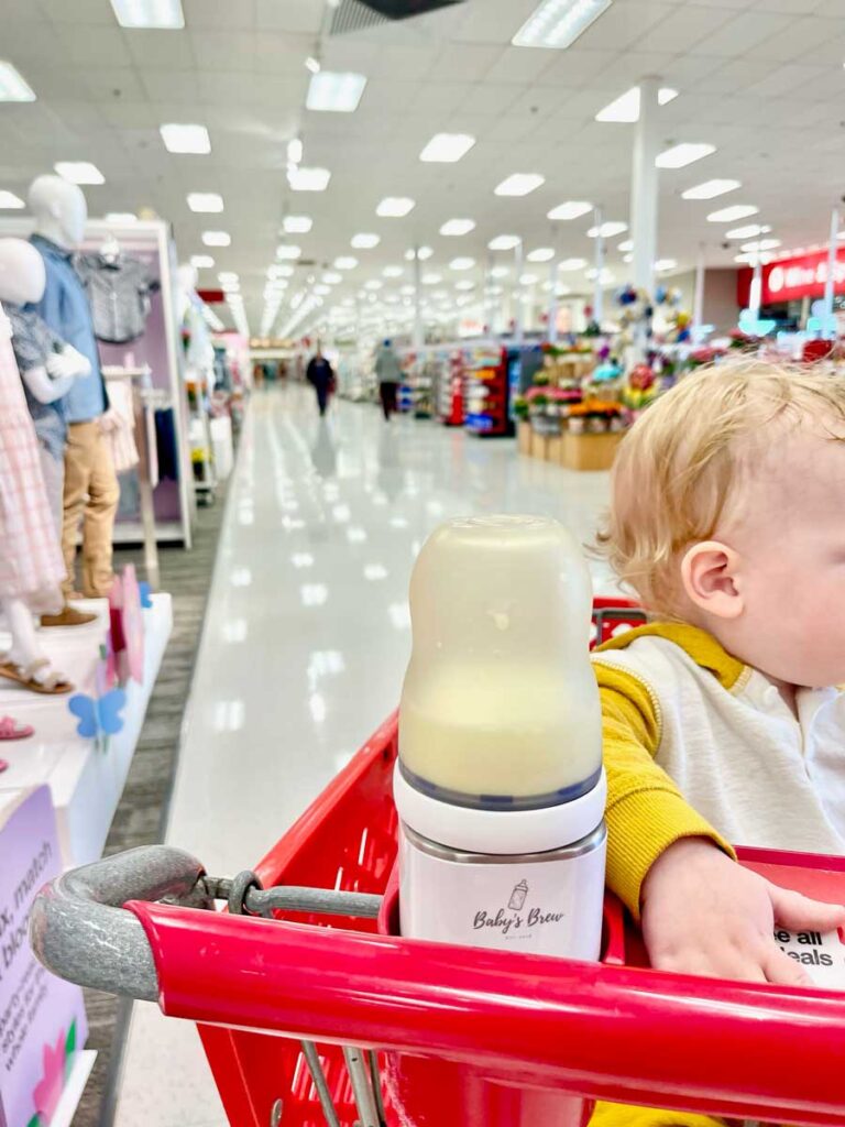 baby in shopping cart with Baby's Brew heating bottle