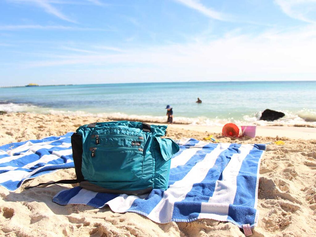 Baby travel blogger Celine Brewer, leaves her diaper bag backpack for travel on the beach in Mexico.
