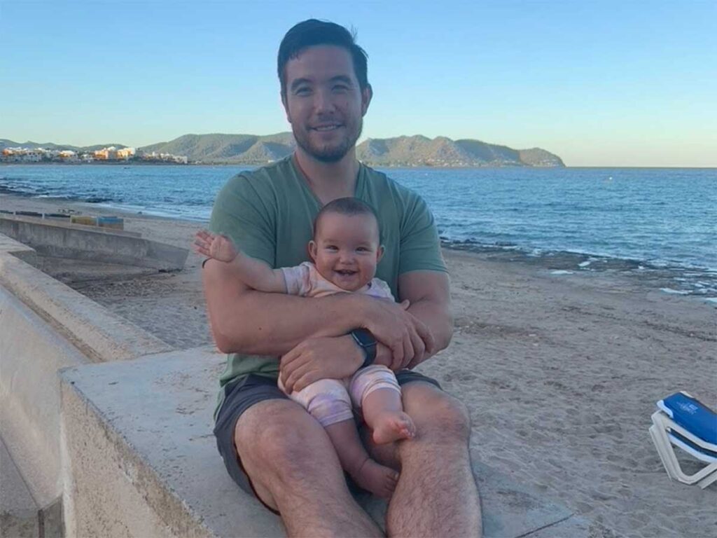 father holding baby on beach in Mallorca