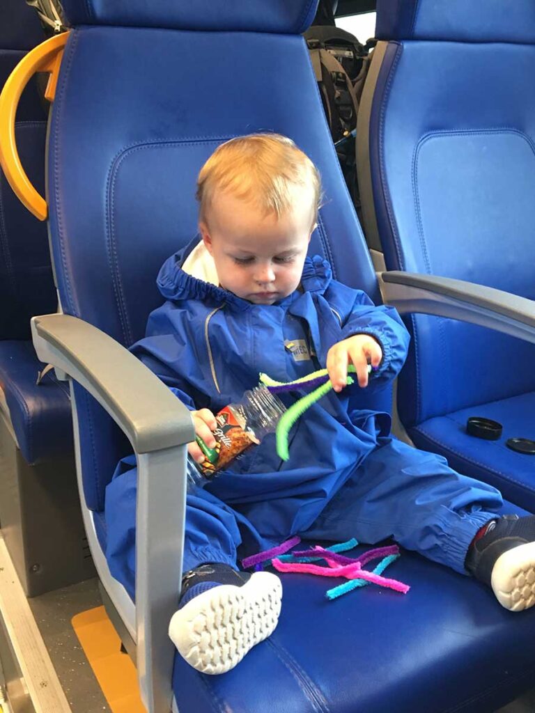 a toddler from BabyCanTravel.com, plays with a screen free DIY toddler travel toy on a family vacation.