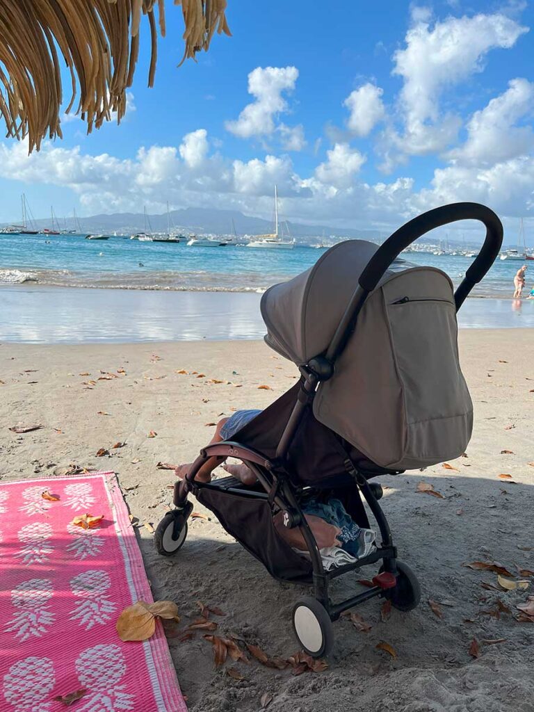 toddler taking nap in stroller on beach - Martinique