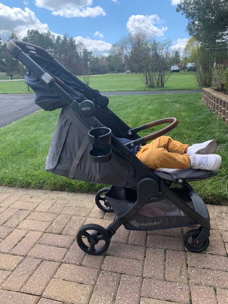 Side view of toddler sleeping in stroller. 