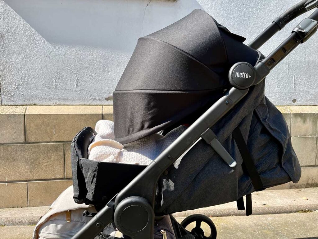 ErgoBaby Metro+ Stroller canopy is large and extended over newborn nest.