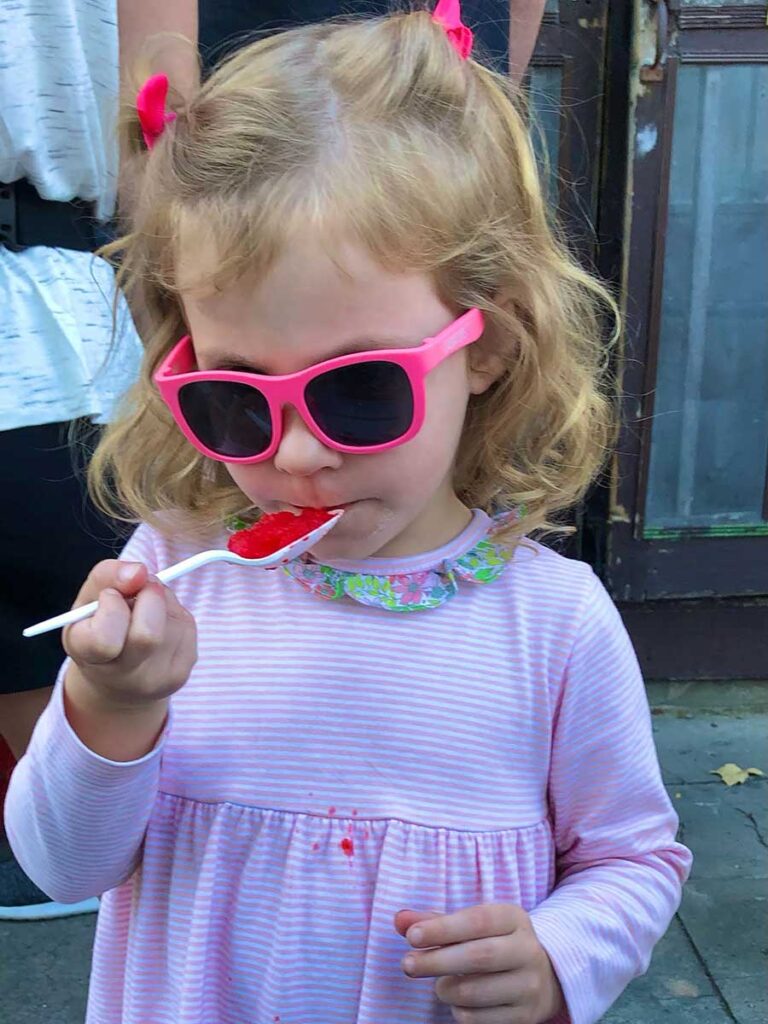 Girl eating frozen treat from spoon. 