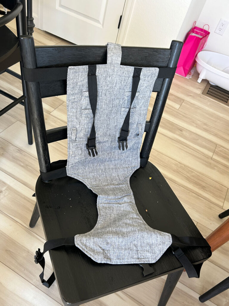 Liuliuby fabric high chair for travel set up on a chair.