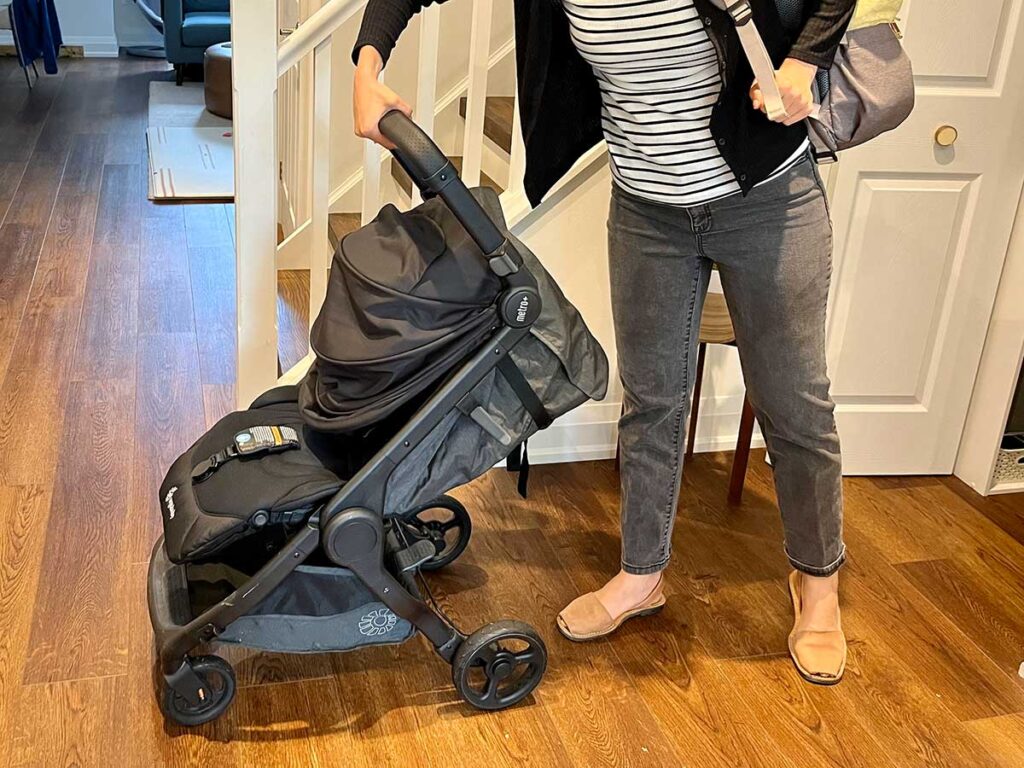 Demonstrating one hand fold of ErgoBaby Metro+ Stroller.