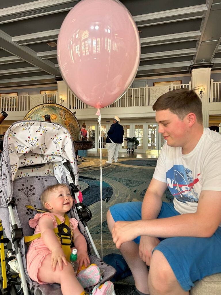 Dad and baby looking at a balloon.