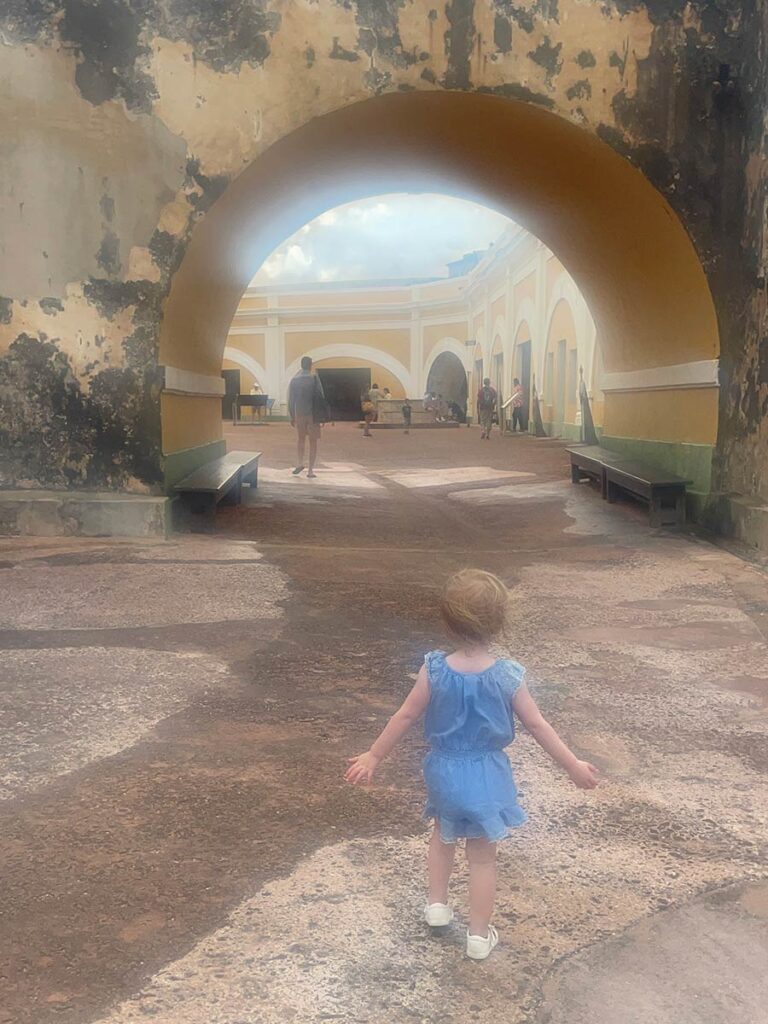 Toddler walking through old San Juan. 