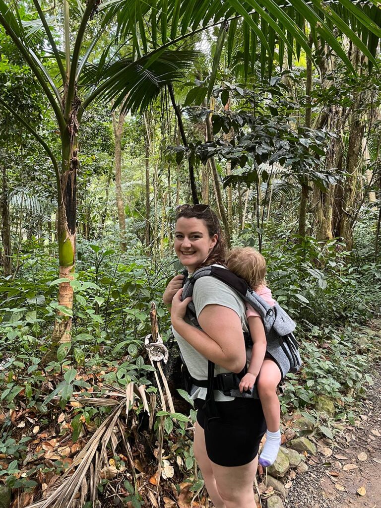 Woman carrying toddler in back baby carrier.