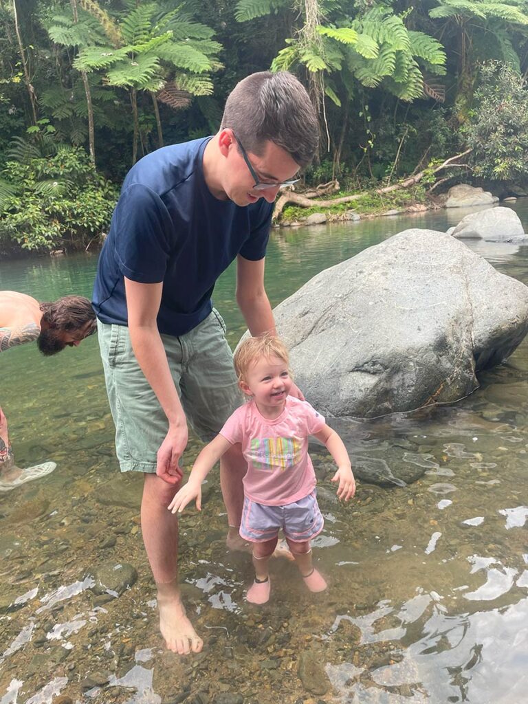 Man and toddler standing in a river.