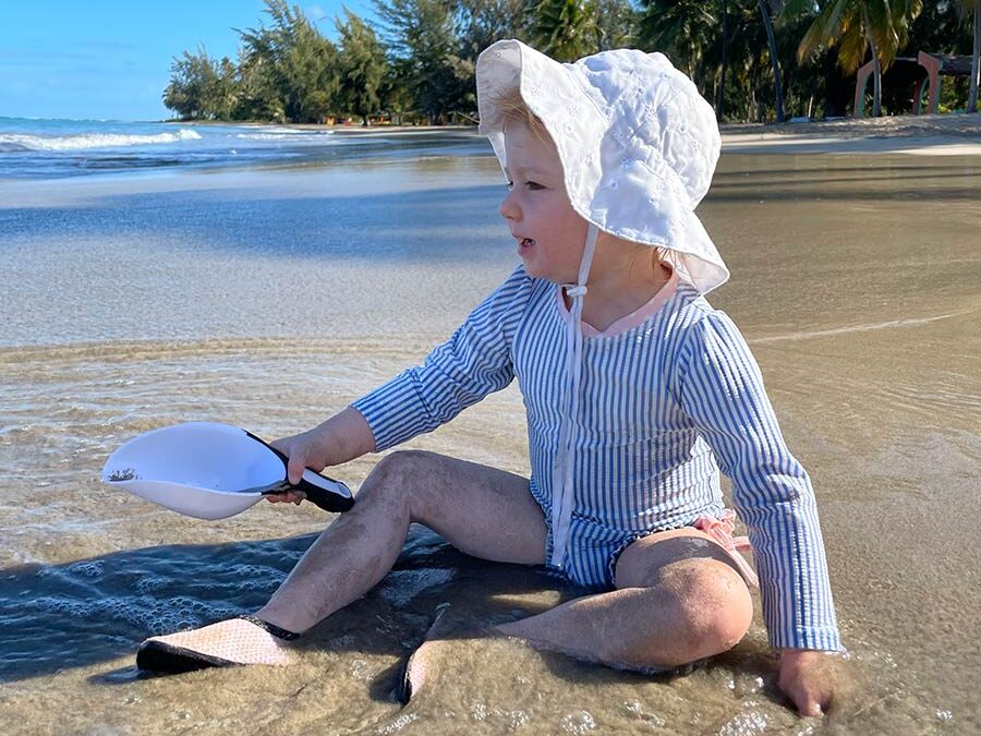 Toddler playing with scoop at the beach in Puerto Rico