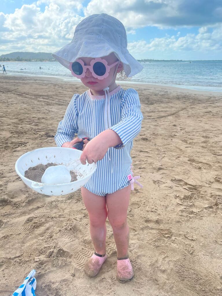 Toddler playing with sand toys at the beach in Puerto Rico.